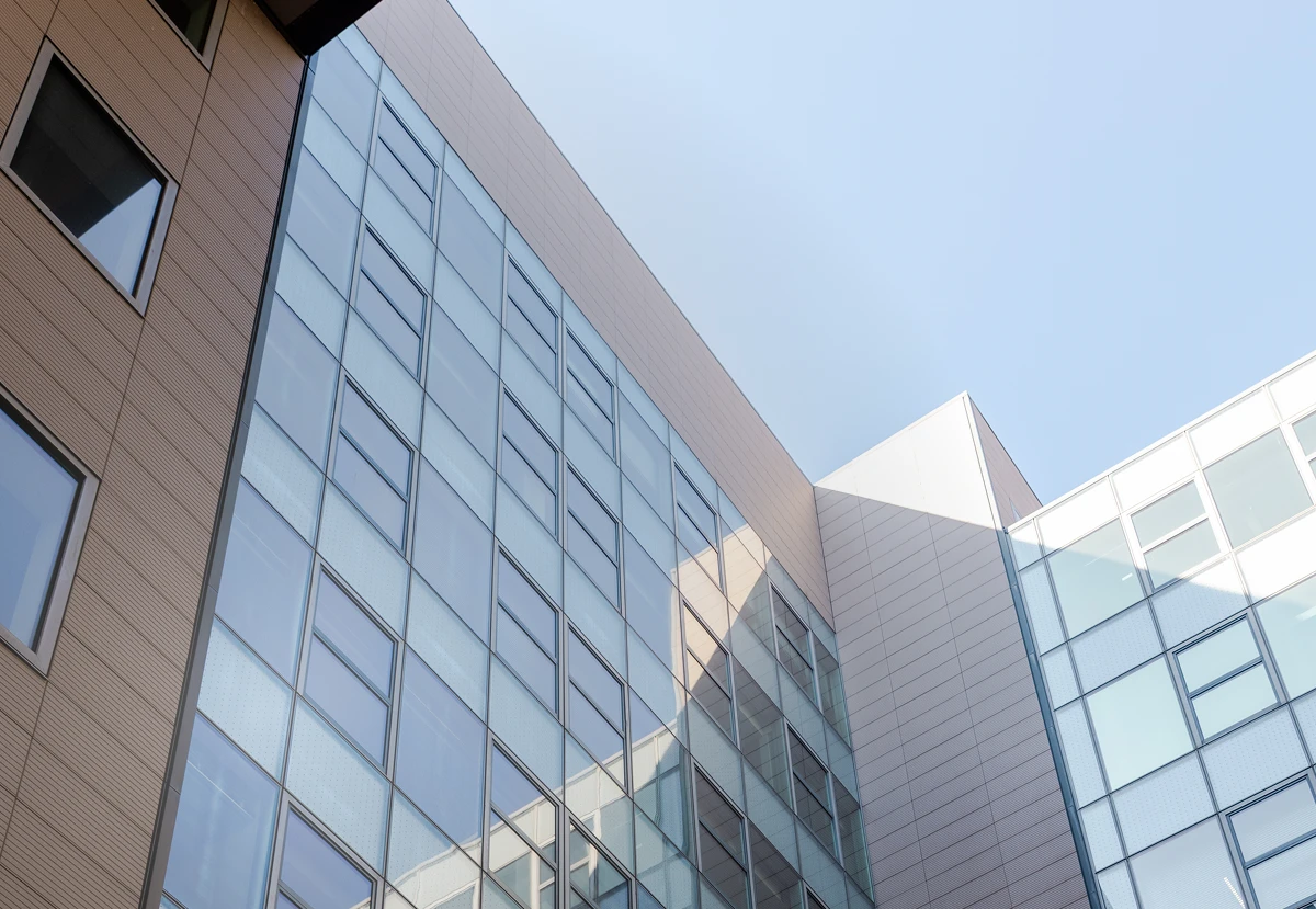 Hero Image Blick hoch zum modernen berlinovo-Büroturm in der Linkstraße, in
großen Glasflächen spiegelt sich die Sonne.