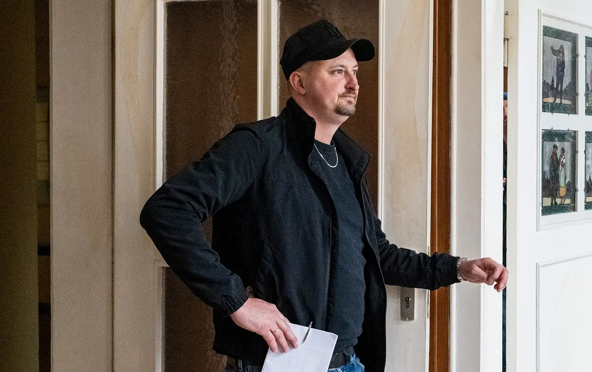 Der Haushandwerker der Invalidensiedlung Christopher Vondey lehnt,
casual gekleidet, am Türrahmen seines Büros.